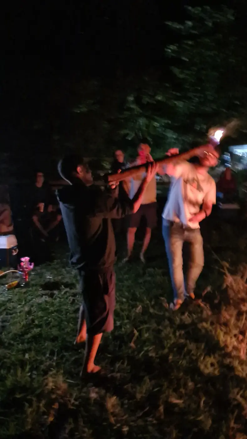 Amigos reunidos perto da fogueira durante a madrugada